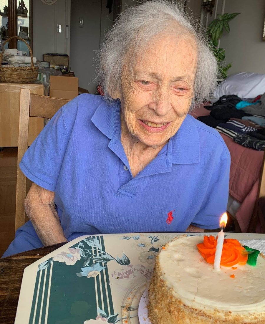 Alice Wimpfheimer smiling beside a birthday cake with a single candle